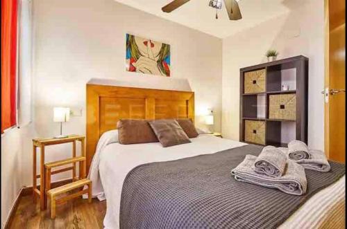 een slaapkamer met een groot bed en handdoeken bij Apartamento moderno Cote in Alicante