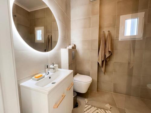a bathroom with a sink and a toilet and a mirror at Capitão Ribeiro Surf House in Costa da Caparica