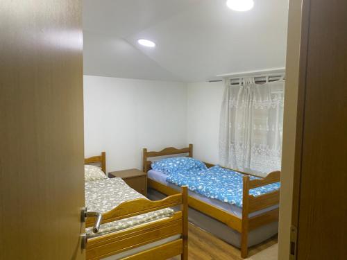 two beds in a room with a window at Apartment Poturmahala in Travnik