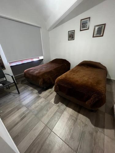 2 camas en una habitación con ventana grande en TRES CERRITOS SALTA en Salta