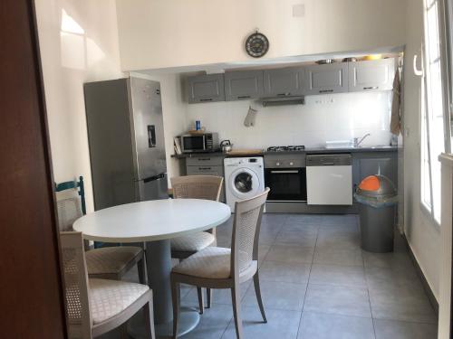 - une cuisine avec une table, des chaises, une table et une cuisinière dans l'établissement Metz-sud - Appartement 120 m2 dans maison du XVIII - Jouy aux Arches entre Nancy et Luxembourg - Proximité toutes commodités, à Jouy-aux-Arches