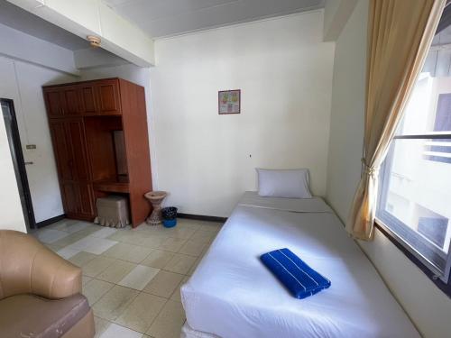 a bedroom with a bed and a couch and a window at Residence Inn Pattaya in Pattaya Central