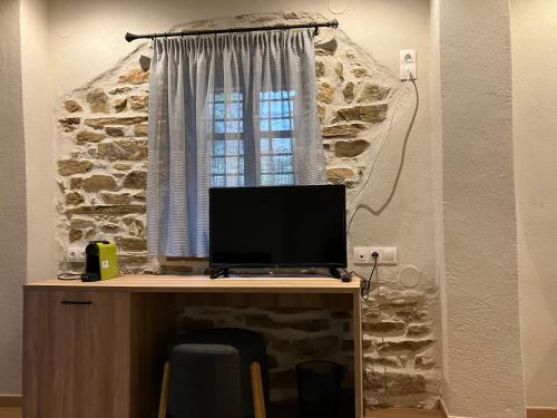 a desk with a computer on it with a window at Melofegaro Guesthouse in Palaios Panteleimon
