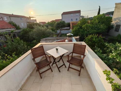 a table and four chairs on a balcony with a view at Apartman Lucija in Murter