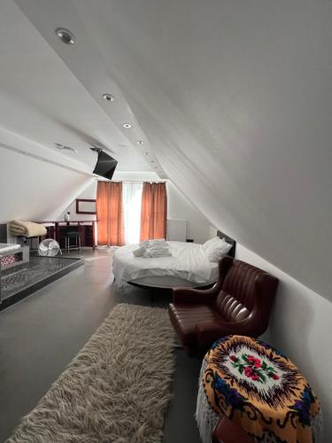 une chambre avec un lit, un canapé et une chaise dans l'établissement Les gites du Valjoly, à Touvent