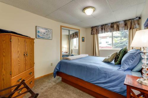 a bedroom with a blue bed and a window at Cozy Apartment Less Than 4 Miles to Downtown Anchorage! in Anchorage