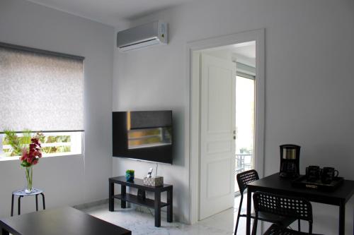 - un salon blanc avec une table et une fenêtre dans l'établissement Amalia Residences, à Nicosie