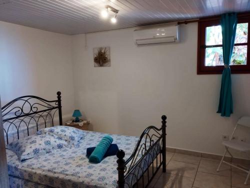 a bedroom with a bed in a room with a window at Appartement d'une chambre avec vue sur la mer terrasse amenagee et wifi a Bouillante a 4 km de la plage in Bouillante