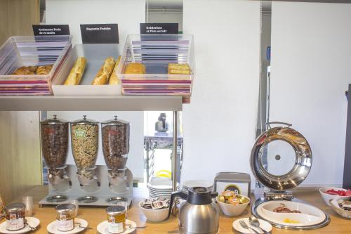 a kitchen counter with a table with some food at Hotel Inn design Vierzon in Vierzon