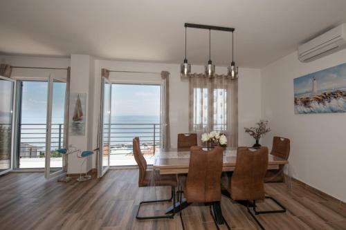 uma sala de jantar com uma mesa e vistas para o oceano em APARTMAN RUBINIĆ em Ičići