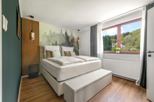 a bedroom with two white beds and a window at Hotel Zweite Heimat Nürburg in Kelberg