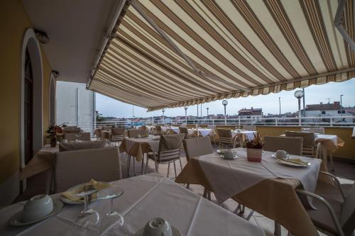 um restaurante com mesas e cadeiras com vista para o oceano em B@B Valbruna em Rovinj