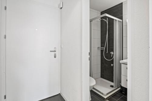 a white bathroom with a toilet and a shower at Pearlstay - City Center Twin Bed Workplace Washer in Winterthur