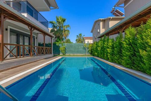 a swimming pool in the backyard of a house at Near By THE LAND OF LEGENDS , VİLLA PARADİSE in Belek
