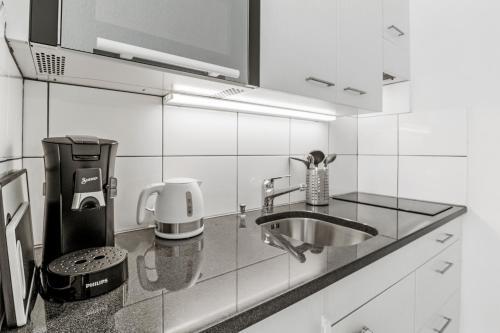 a kitchen with a sink and a coffee maker at Pearlstay - City Center Twin Bed Workplace Washer in Winterthur