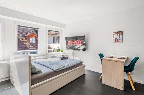 a bedroom with a bed and a desk and a window at City Center-Twin Bed-Coffee-Workplace-Washer in Winterthur