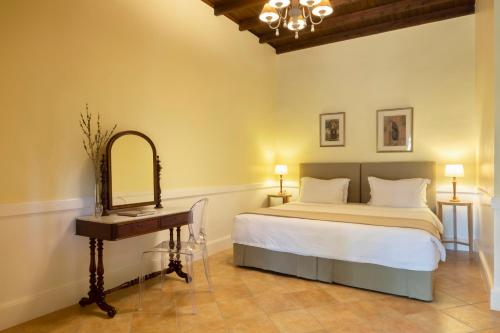a bedroom with a bed and a dressing table and a mirror at Pelecas Country Club in Pelekas