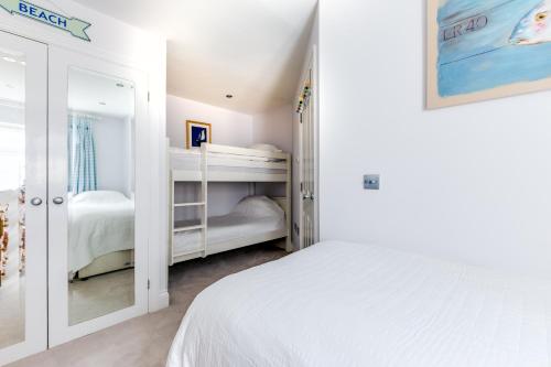 biała sypialnia z 2 łóżkami piętrowymi w obiekcie Rock Lobster w mieście Port Isaac