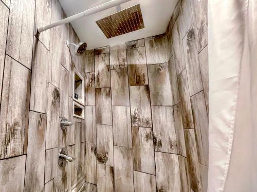 ein Bad mit einer Holzwand und einer Dusche in der Unterkunft Penn Lodge Hotel & Suites Philadelphia - Bensalem in Bensalem