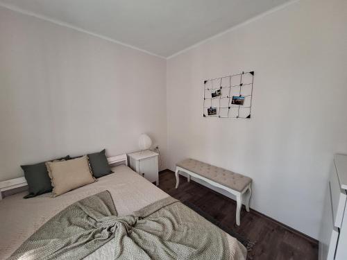 1 dormitorio con cama y banco. en Szitakötő en Siófok