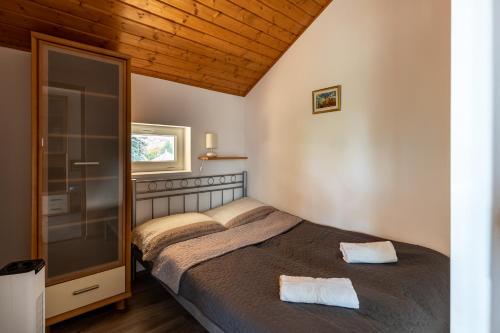 ein Schlafzimmer mit einem Bett mit zwei Handtüchern darauf in der Unterkunft Adél Vendégház in Zamárdi