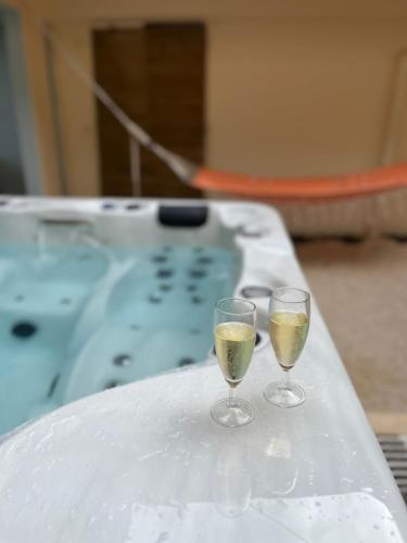 two glasses of champagne sitting on top of a tub at VT cottage in Rivière-Pilote