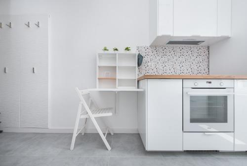 - une cuisine avec des placards blancs et une échelle dans l'établissement Apartament Nowy Świat 3, à Gliwice