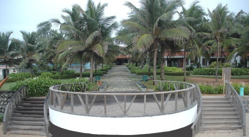 a spiral staircase in a resort with palm trees at Radisson Blu Resort Temple Bay Mamallapuram in Mahabalipuram