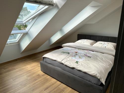 uma cama num quarto com duas janelas em Pod Czwórką em Rewa