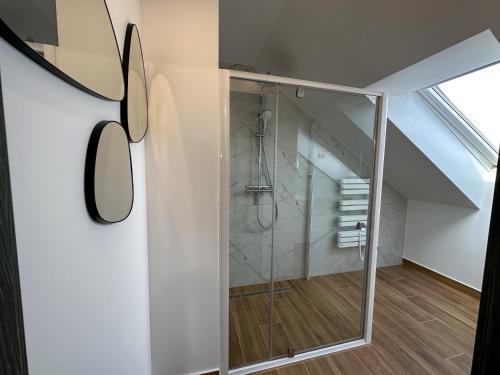 a bathroom with a glass shower in a attic at Pod Czwórką in Rewa