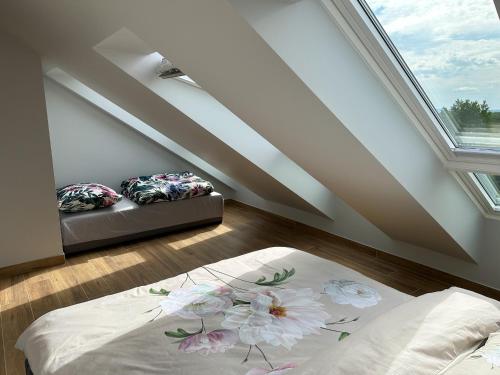 a attic room with two beds and a window at Pod Czwórką in Rewa