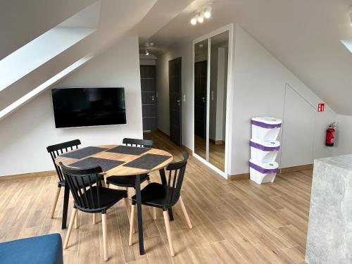 a dining room with a table and chairs and a tv at Pod Czwórką in Rewa