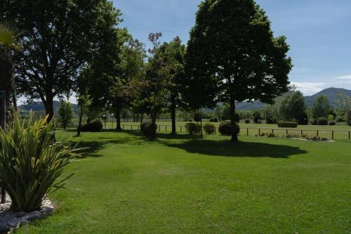 a field of grass with trees and a fence at Hotel Terme Leonardo in Abano Terme