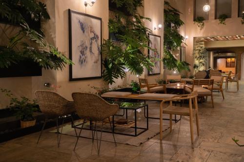 un vestíbulo con mesas, sillas y plantas en Casa del Alma Hotel Boutique & Spa en San Cristóbal de Las Casas