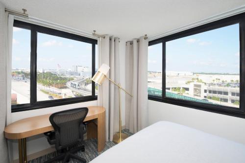 a hotel room with a desk and windows at Sheraton Miami Airport Hotel and Executive Meeting Center in Miami