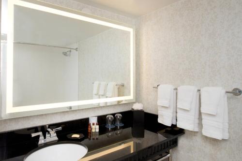 a bathroom with a sink and a mirror and towels at Sheraton Miami Airport Hotel and Executive Meeting Center in Miami