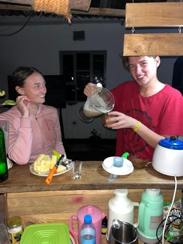 a man and a woman standing at a counter preparing food at Meleji Studio House in Arusha