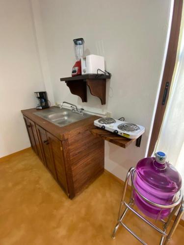 a kitchen with a sink and a chair in a room at Casa Suites Minizoo in Puerto Escondido