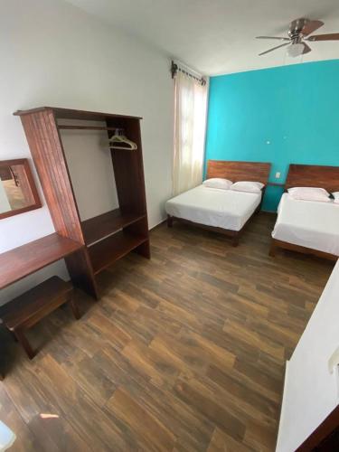 a room with two beds and a wooden floor at Casa Suites Minizoo in Puerto Escondido