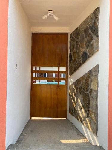 a wooden door in a room with a stone wall at Casa Suites Minizoo in Puerto Escondido
