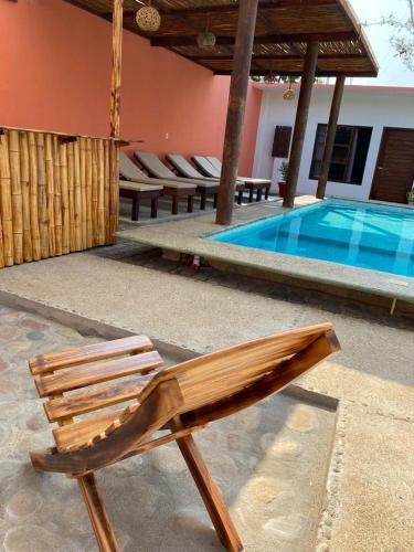a wooden chair sitting next to a swimming pool at Casa Suites Minizoo in Puerto Escondido