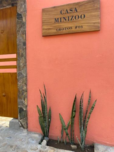 a sign on the side of a building with two plants at Casa Suites Minizoo in Puerto Escondido