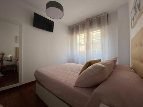 a white bedroom with a bed with a window at LALIN CENTRO URBANO, CÓMODO Y FUNCIONAL in Lalín