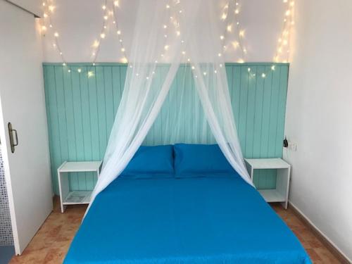 sypialnia z niebieskim łóżkiem z oświetleniem w obiekcie Petit Room, Habitación w mieście Conil de la Frontera