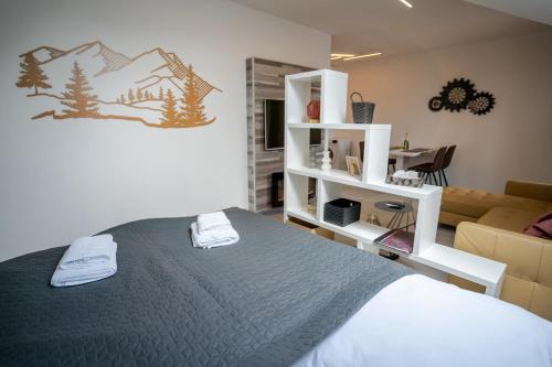 ein Schlafzimmer mit einem Bett und ein Wohnzimmer mit einem Sofa in der Unterkunft Ski & Sun B9 in Liptovský Mikuláš