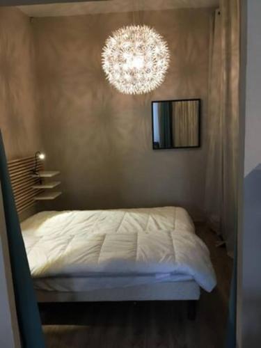 拉西約塔的住宿－Apartment between land and sea in La Ciotat，卧室配有白色的床和吊灯。