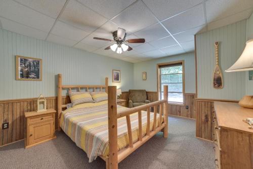 una camera con letto e ventilatore a soffitto di Rose City Cabin with Fire Pit and Lake Access 