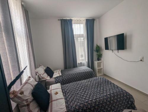 um pequeno quarto com 2 camas e uma televisão em Schönes Apartment am Rhein - Zentral em Koblenz