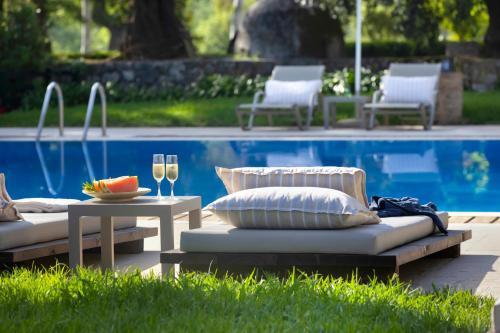 two lounge chairs and a table next to a pool at Pelecas Country Club in Pelekas