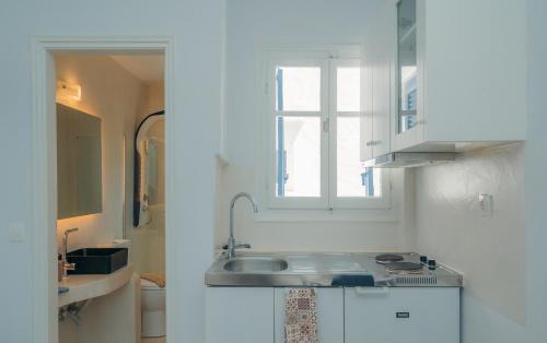 アポロニアにあるEsmeralda Apartmentsのシンクと窓のある白いキッチン